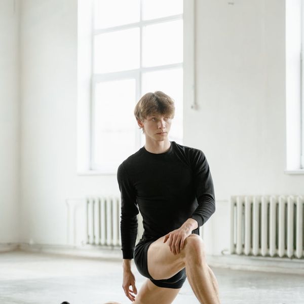 Silhouette of a man stretching against a sunrise, symbolizing energy.